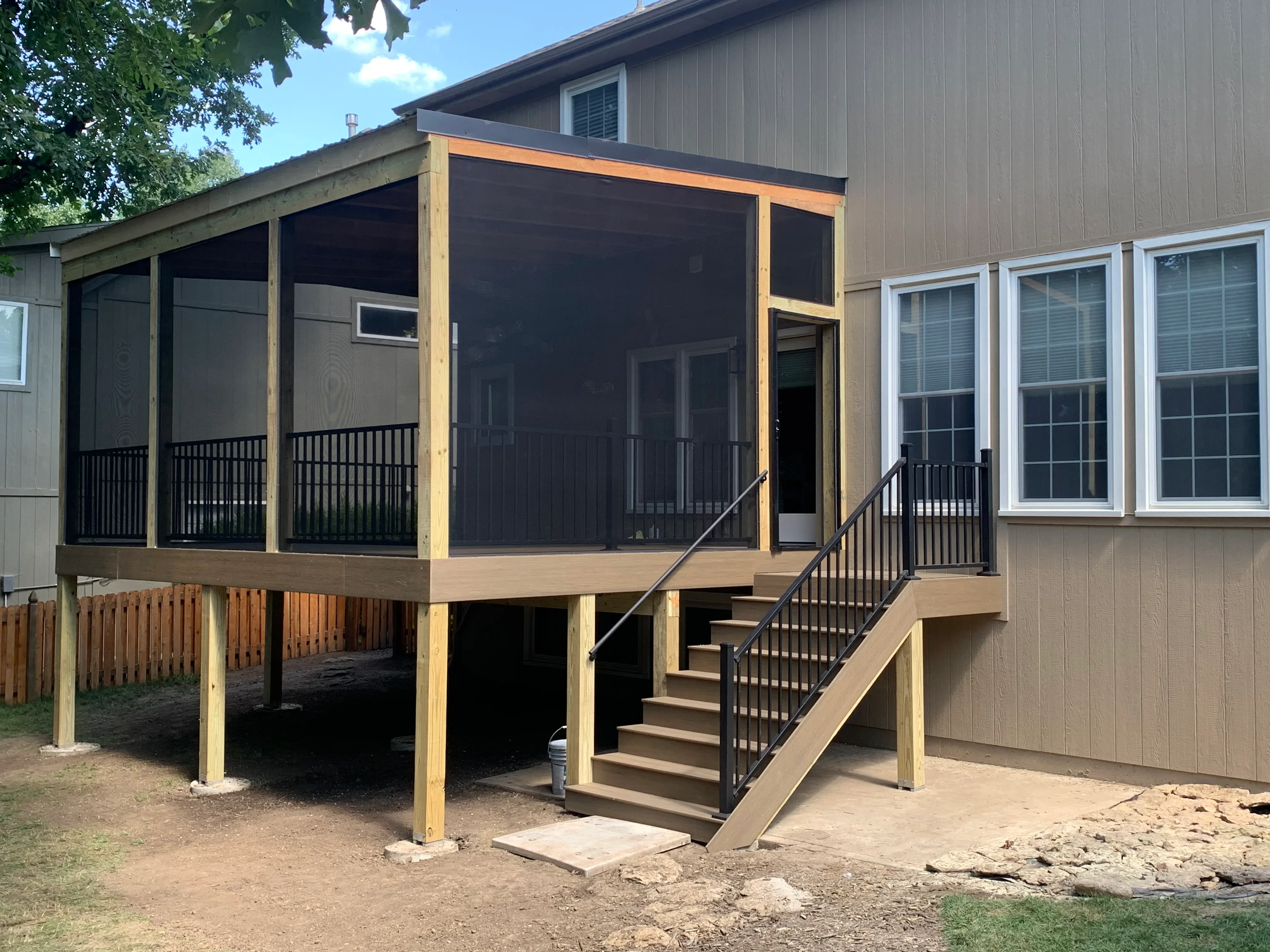 Elevated deck with screened porch, composite decking, black mesh screens, and metal railings