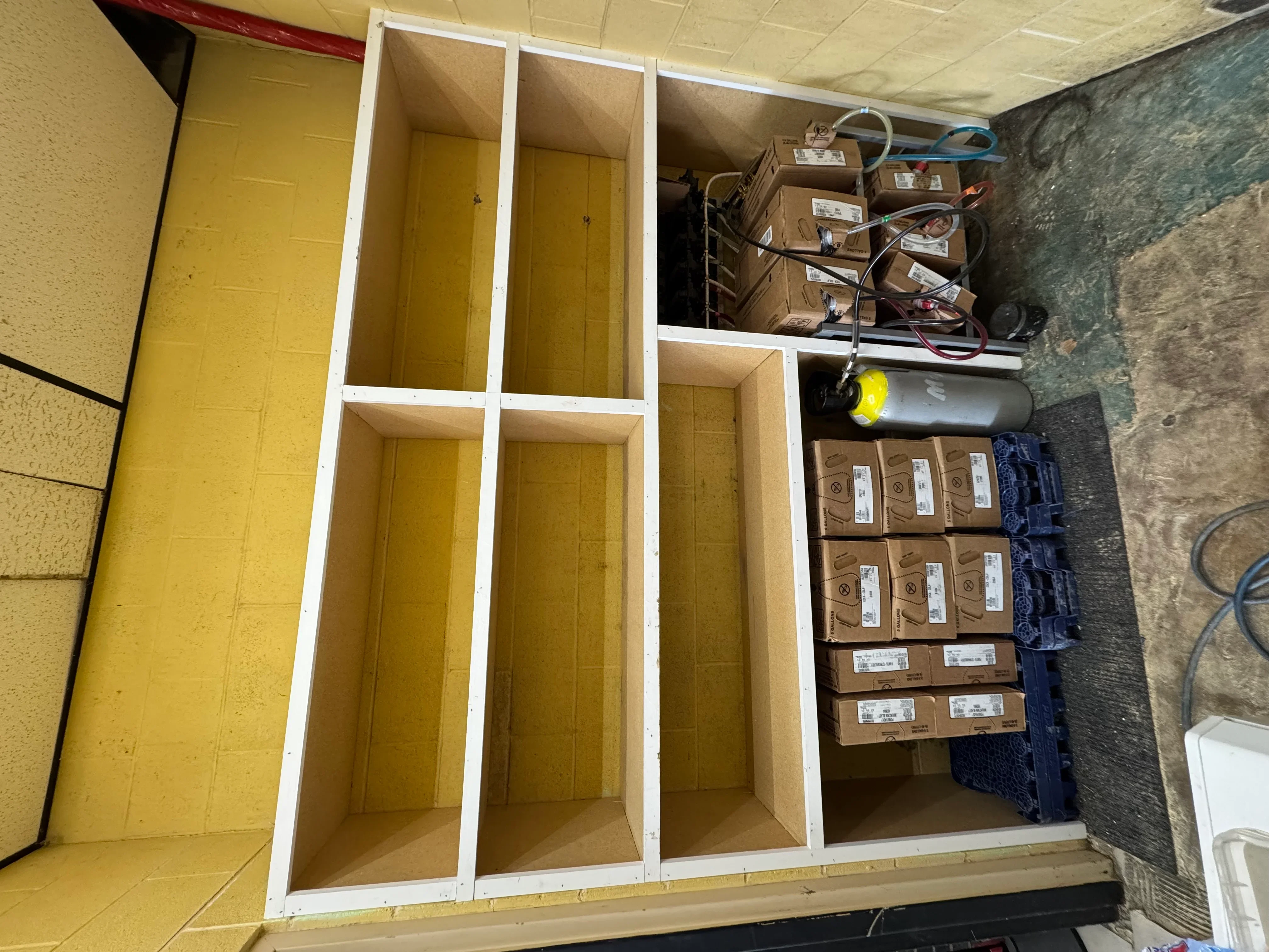 Custom built-in cabinetry with white frames, yellow doors and panels, multiple compartments for storage