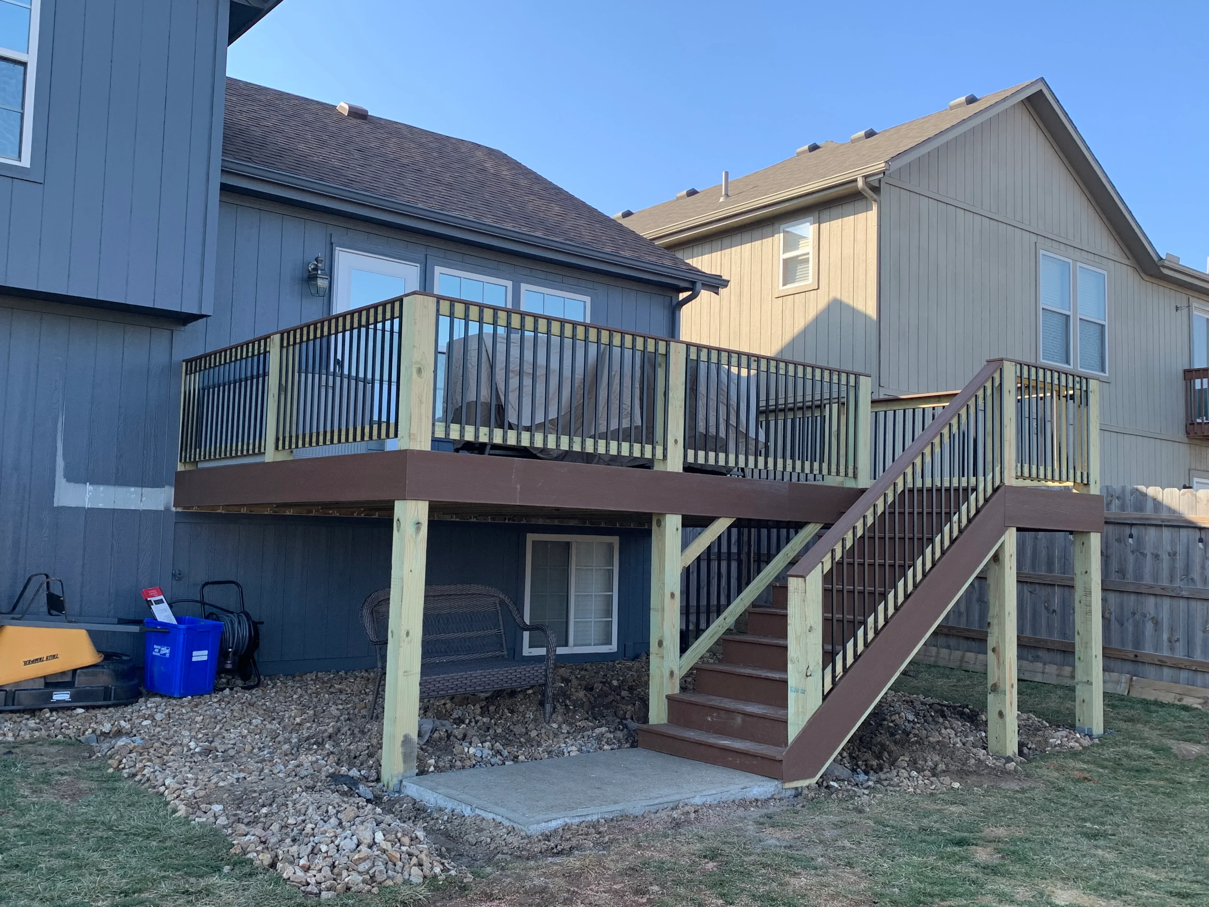 Two-level composite deck with metal railings, stairs, and pressure-treated framing