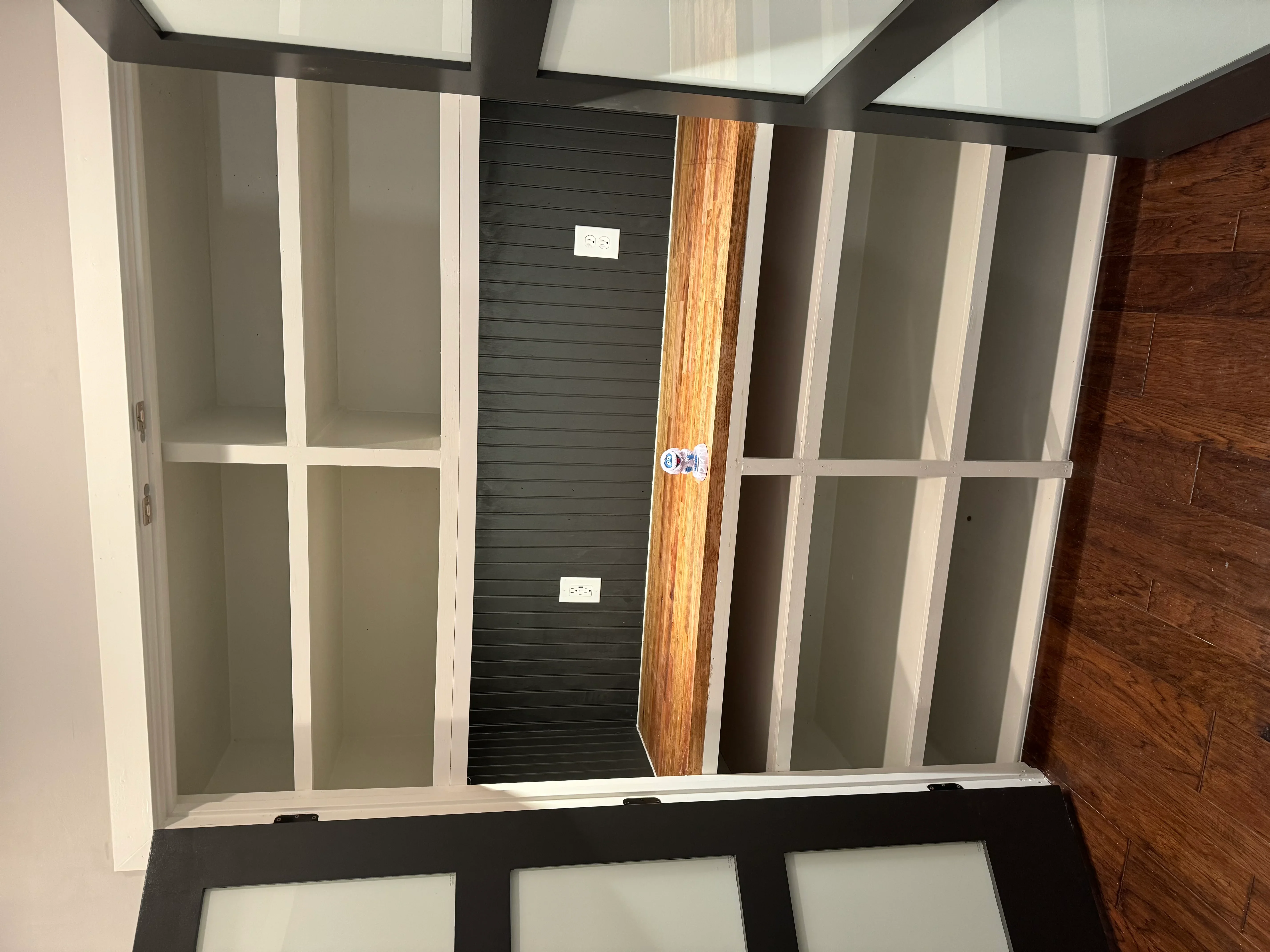 White framed glass panel walls with black shiplap accent wall and wood door installation